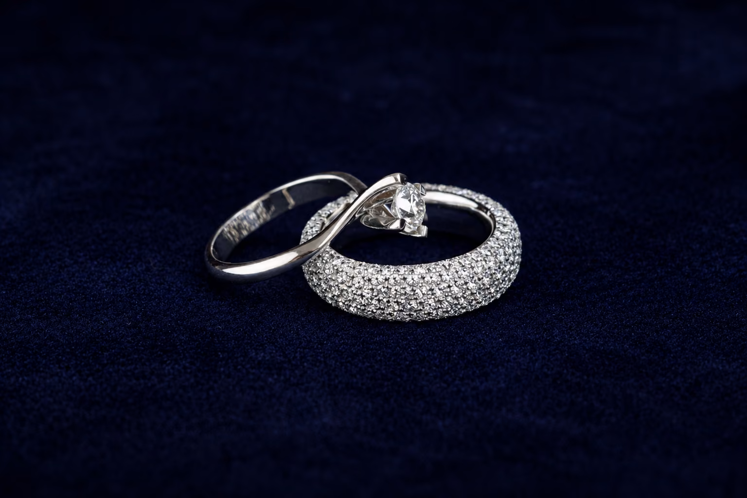 Dos anillos de diamantes sobre terciopelo azul oscuro