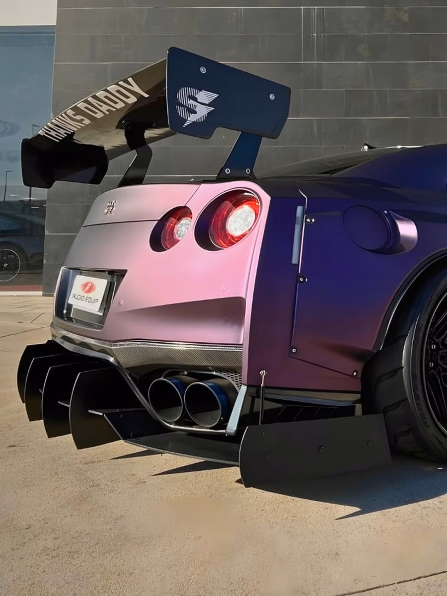 Nissan GT-R preparado, con carrocería ensanchada y alerón trasero, en acabado camaleón violeta y rosa