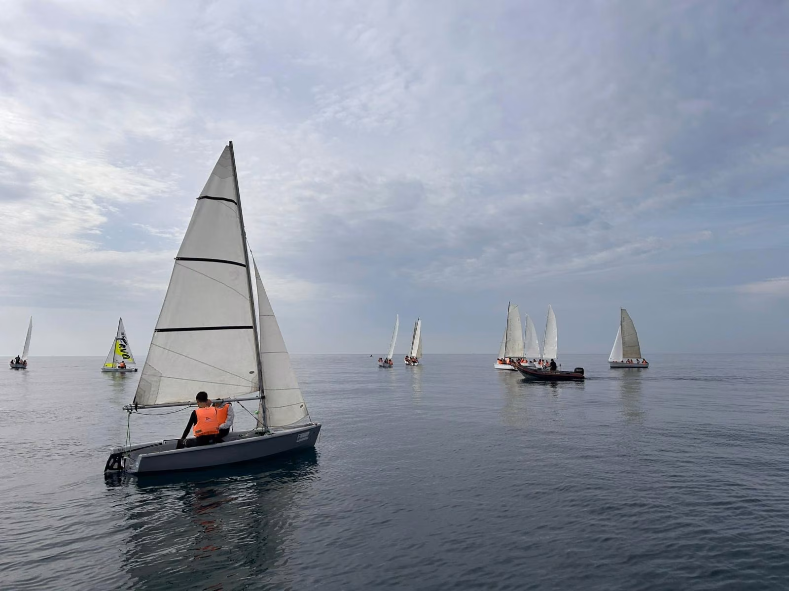 Jóvenes navegando en pequeños veleros durante una jornada de vela